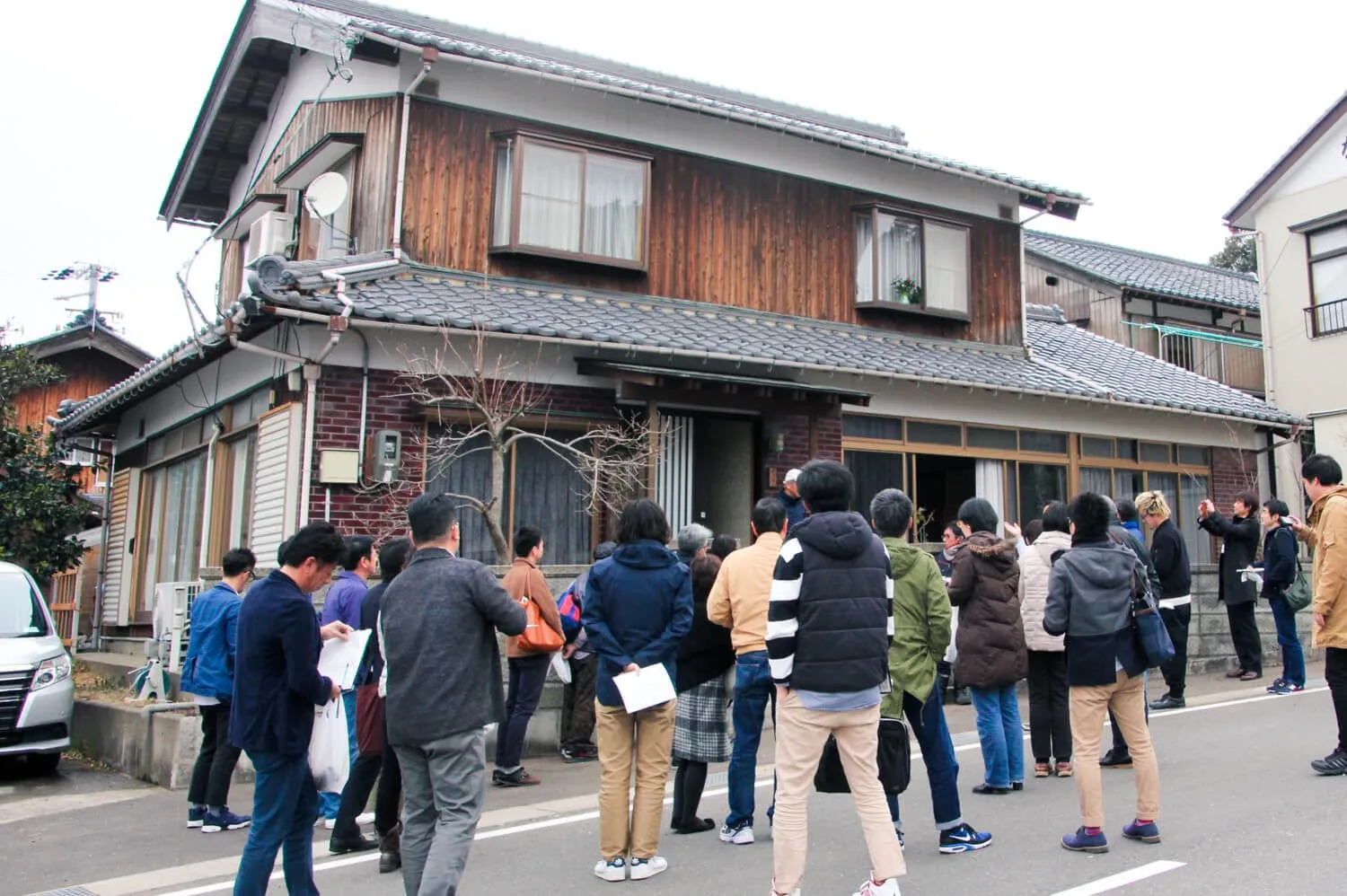 古い民家の前に集まり、説明を聞く空き家見学ツアーの参加者